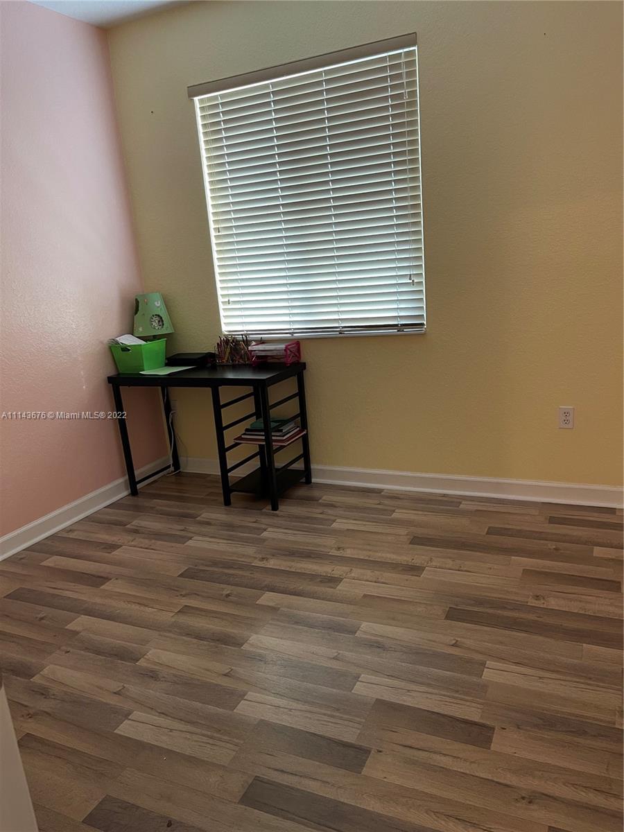 23744 Southwest 108th Court Homestead, FL 33032 - Photo 16 of 22 a view of a room with wooden floor and a window