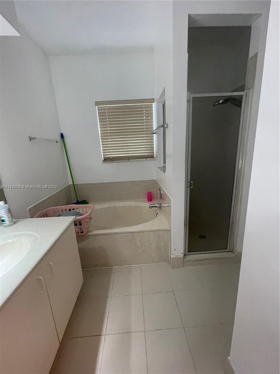23744 Southwest 108th Court Homestead, FL 33032 - Photo 19 of 22 a bathroom with a bathtub and a shower