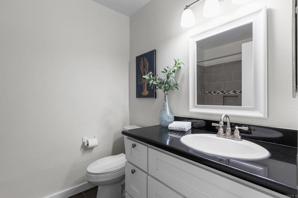 2992 Brandon Circle Carlsbad, CA 92010 - Photo 28 of 69 a bathroom with a granite countertop sink and a mirror with toilet
