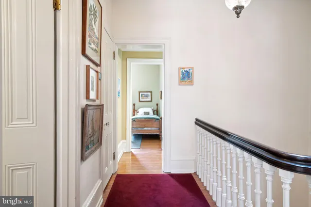 a view of a hallway with wooden floor and furniture