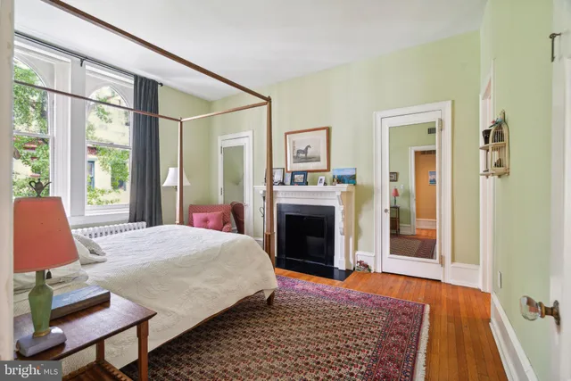 a bedroom with a bed and a lamp on dresser