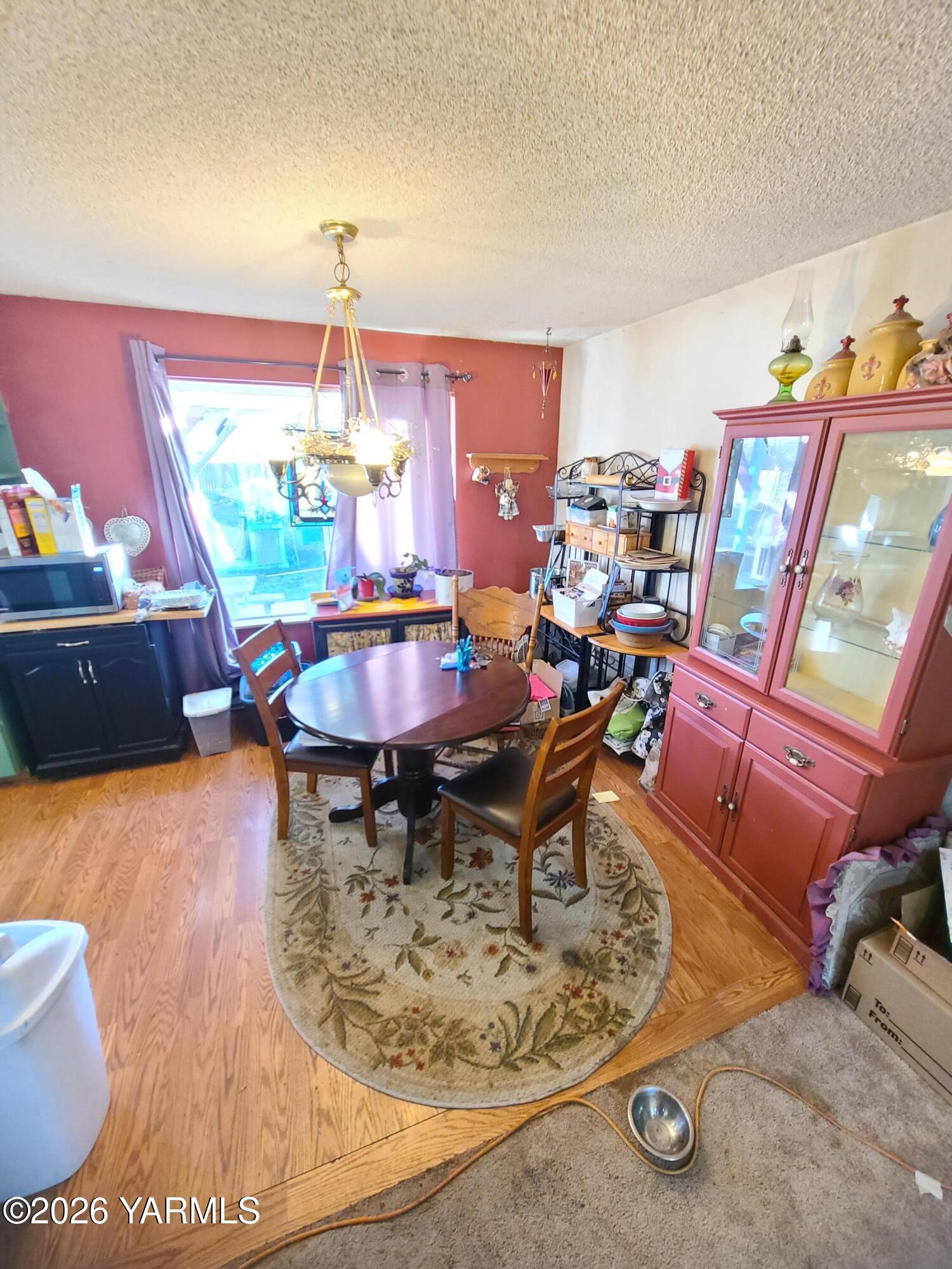 10608 Hackett Road Yakima, WA 98903 - Photo 8 of 25 a view of a dining room with furniture one side kitchen view and wooden floor