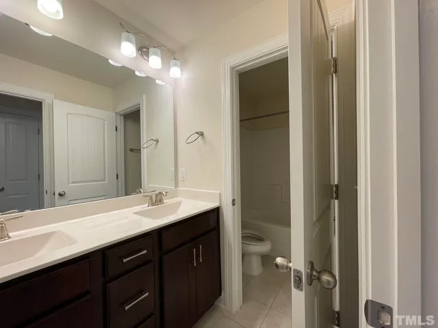 a bathroom with a double vanity sink and a mirror
