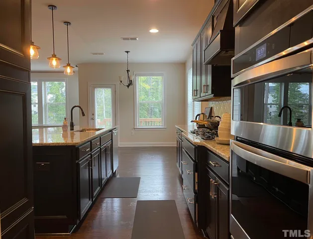a kitchen with counter top space a sink a window and stainless steel appliances