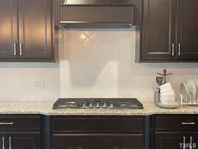 a view of room with granite countertop cabinets and a stove