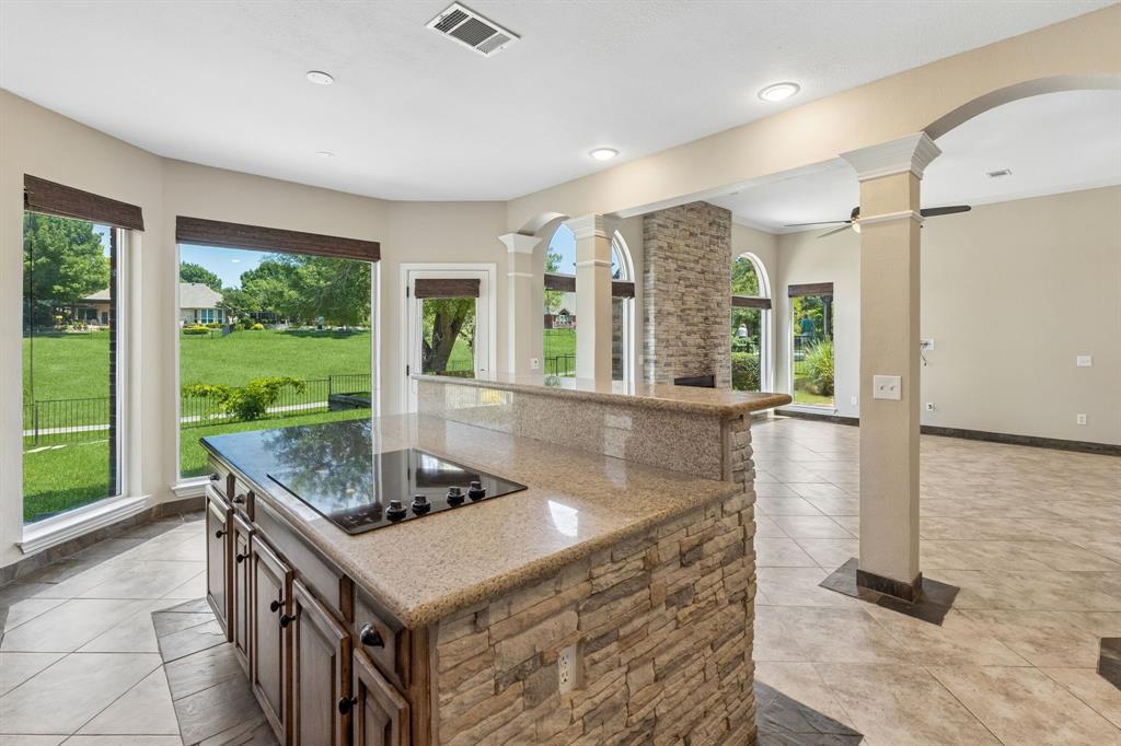 2925 Sunset Ridge McKinney, TX 75072 - Photo 13 of 33 This open kitchen design with extensive granite counter space, custom cabinetry, stone-accented island, and spectacular views, overlook the backyard and golf course.