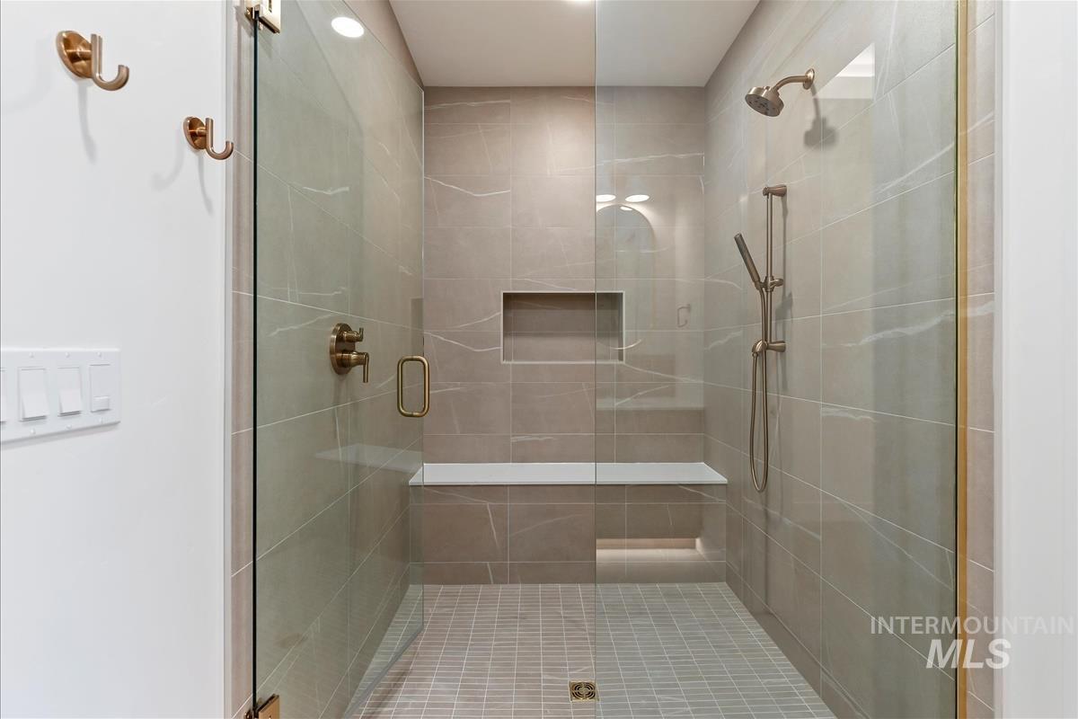 3213 West Moore Street Boise, ID 83702 - Photo 21 of 32 Glass-enclosed shower with full tile surround, integrated bench, and recessed shelving