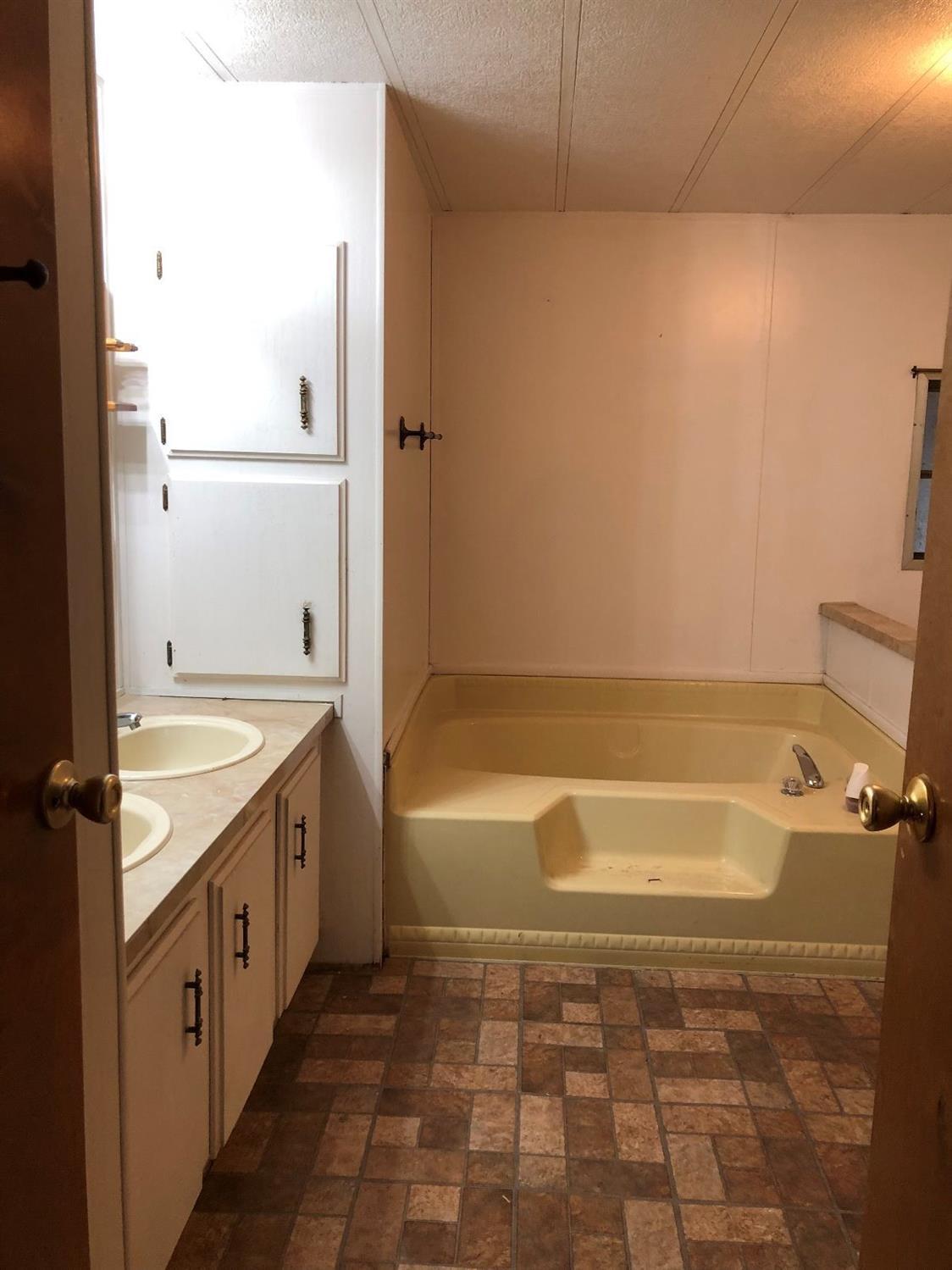 6226 East Evans Creek Road, Unit 15 Rogue River, OR 97537 - Photo 25 of 30 a bathroom with a granite countertop sink a toilet and bathtub