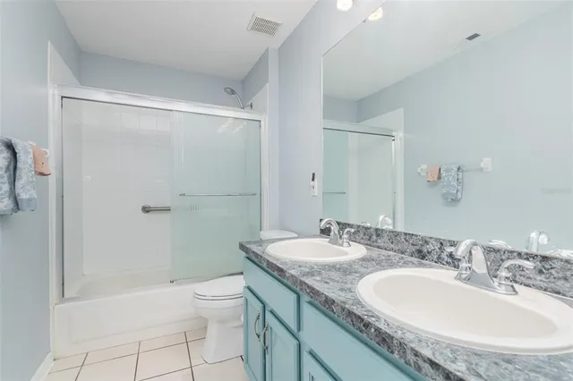 a bathroom with a granite countertop sink a toilet and shower
