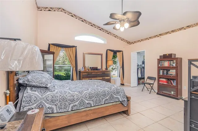 a bedroom with a large bed and a chandelier