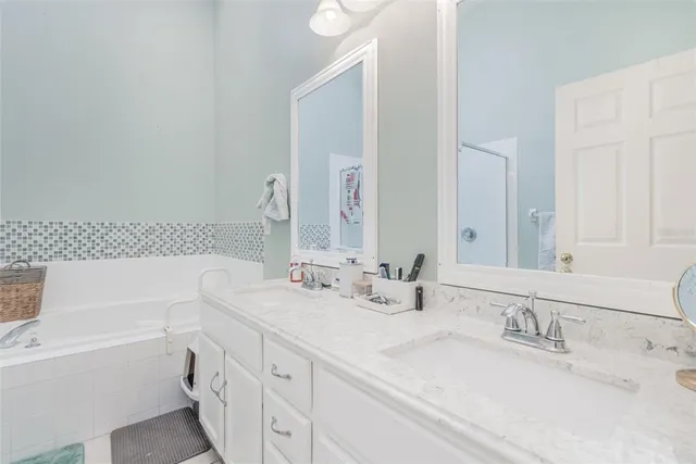 a bathroom with a tub sink and a mirror