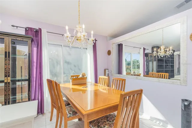 a dining room with furniture a chandelier and window