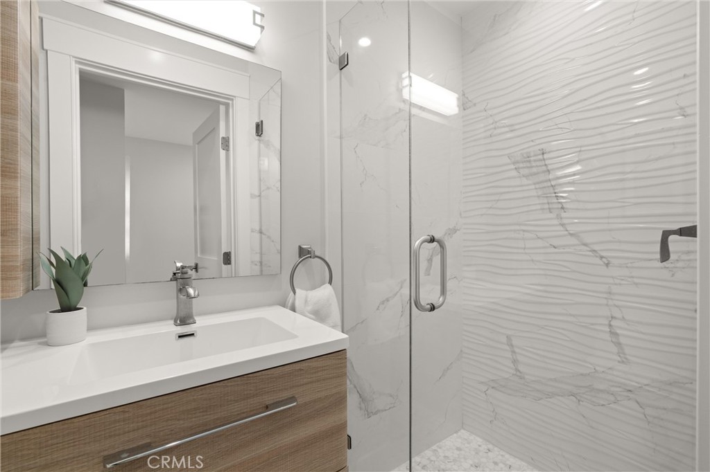 16760 A Bayview Drive Sunset Beach, CA 90742 - Photo 39 of 53 a bathroom with a sink a mirror and shower