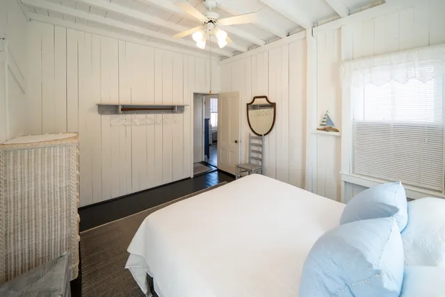 a bed sitting in a spacious bedroom next to a window