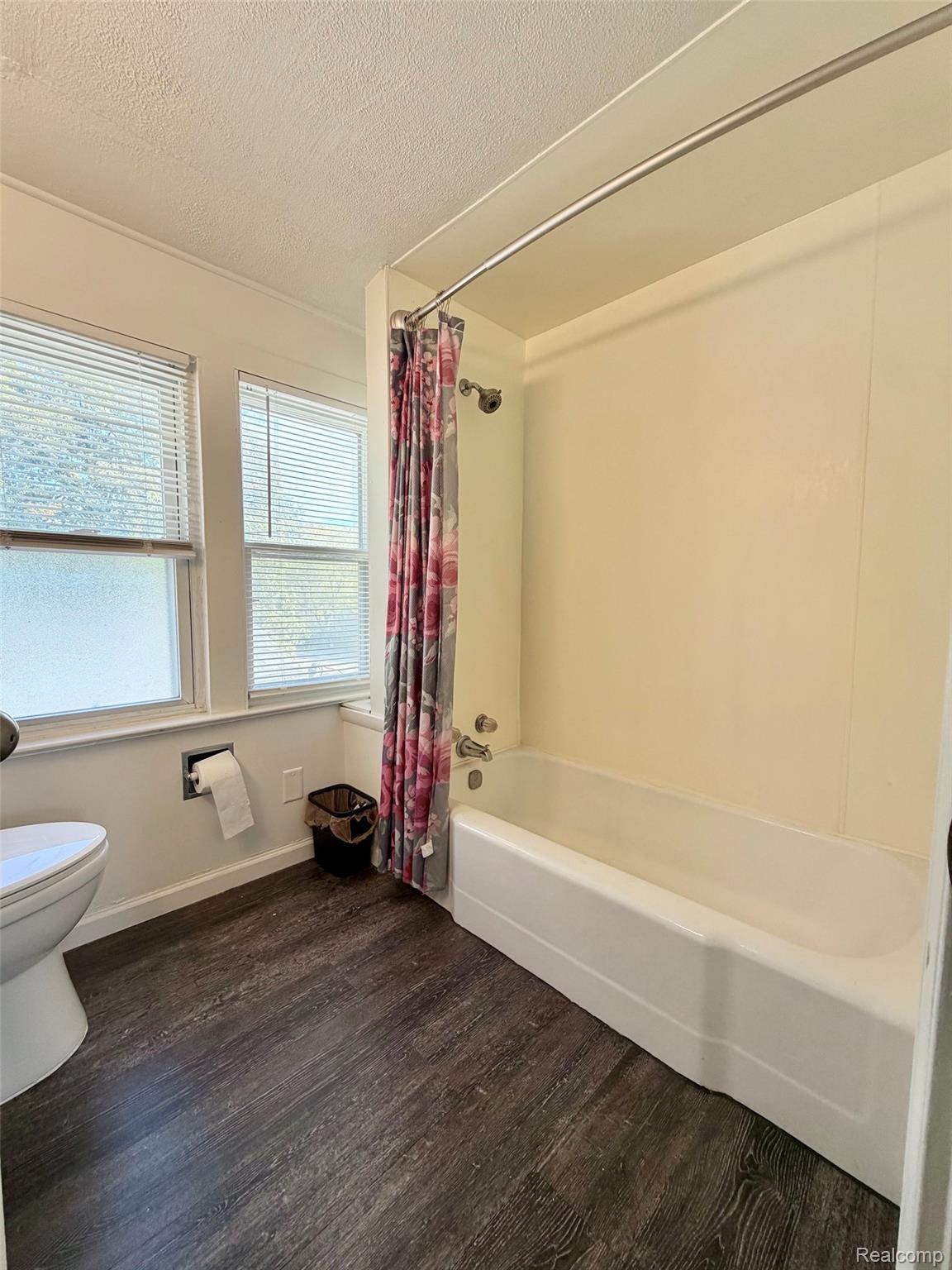 2840 Miller Road Flint, MI 48503 - Photo 28 of 49 Full bathroom featuring a white tub with shower, wood-finish flooring, and multiple windows with blinds