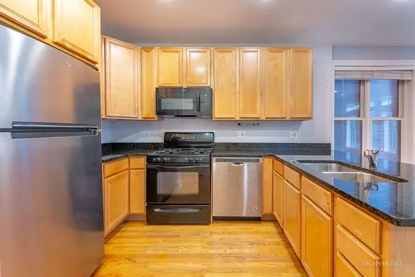 a kitchen with stainless steel appliances a stove a sink and a microwave