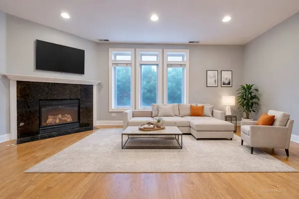 a living room with furniture a flat screen tv and a fireplace