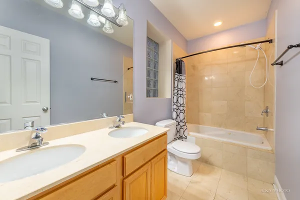 a bathroom with a granite countertop sink a large mirror and a bathtub