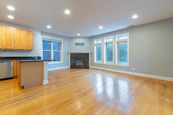 a view of empty room with wooden floor and fireplace