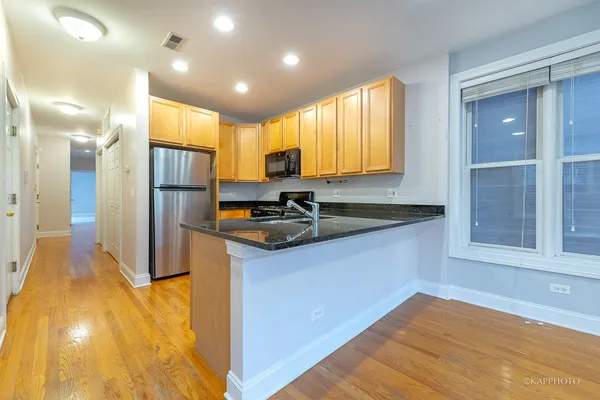 a view of kitchen with stainless steel appliances granite countertop a sink and a refrigerator
