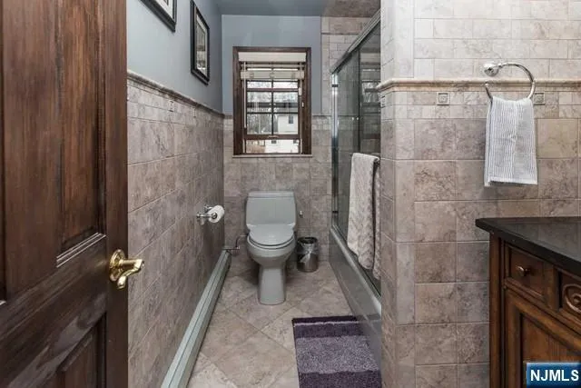 a bathroom with a granite countertop toilet and a shower