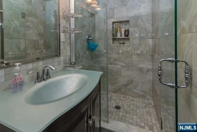 a bathroom with a sink shower and a mirror