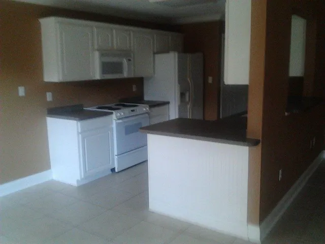 a kitchen with a refrigerator and a stove top oven