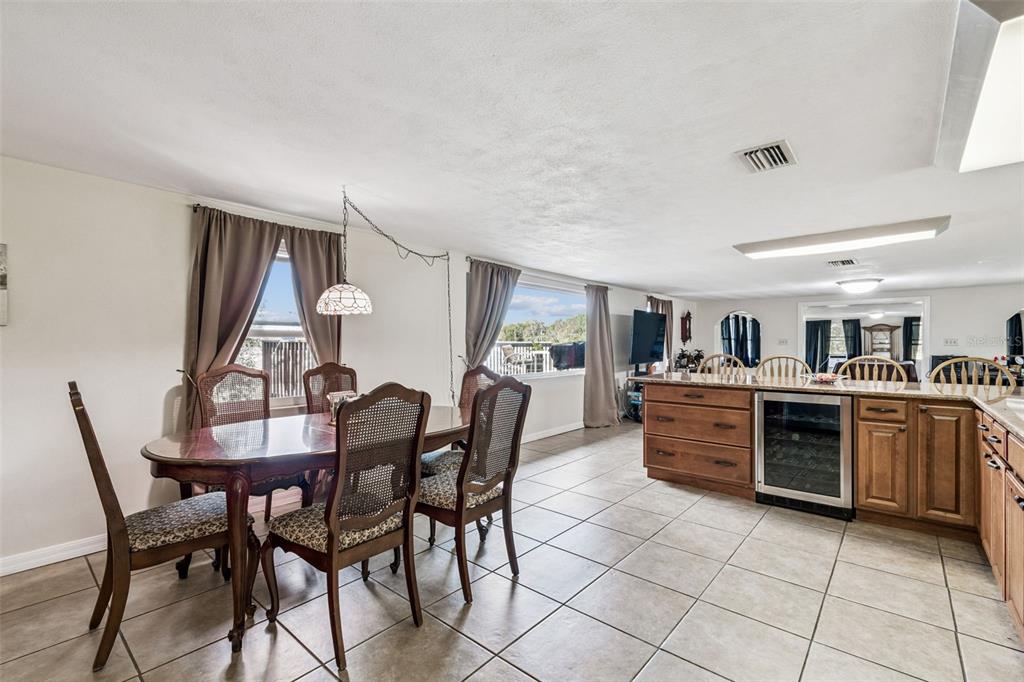 37440 Phelps Road Zephyrhills, FL 33541 - Photo 6 of 80 a kitchen with stainless steel appliances kitchen island granite countertop a table chairs and a sink