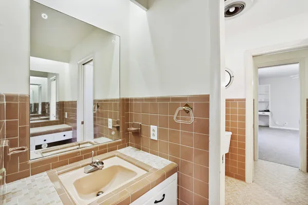 a bathroom with a granite countertop bathtub shower sink mirror and toilet
