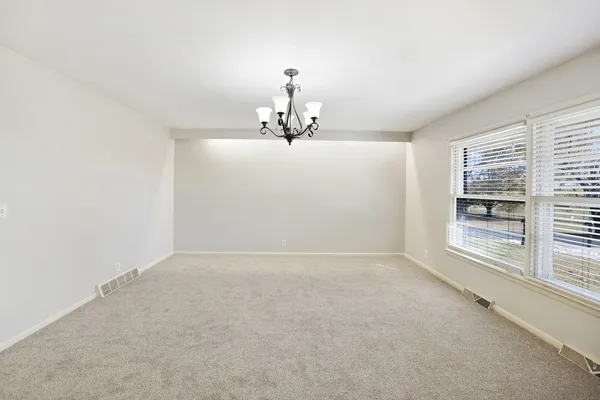 a view of a room with a chandelier fan and windows