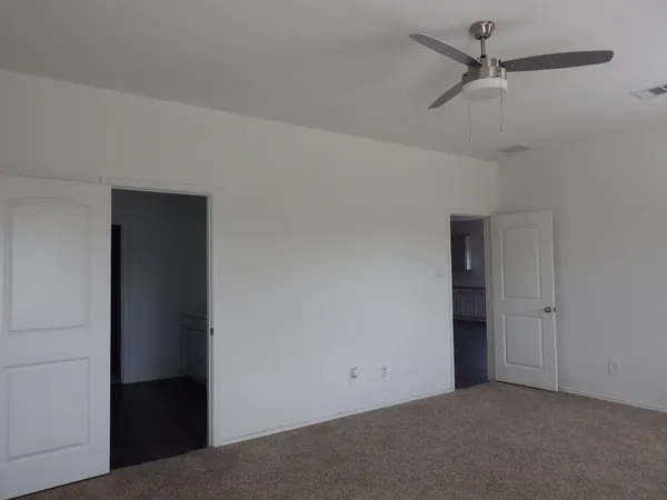 an empty room with a ceiling fan and a window