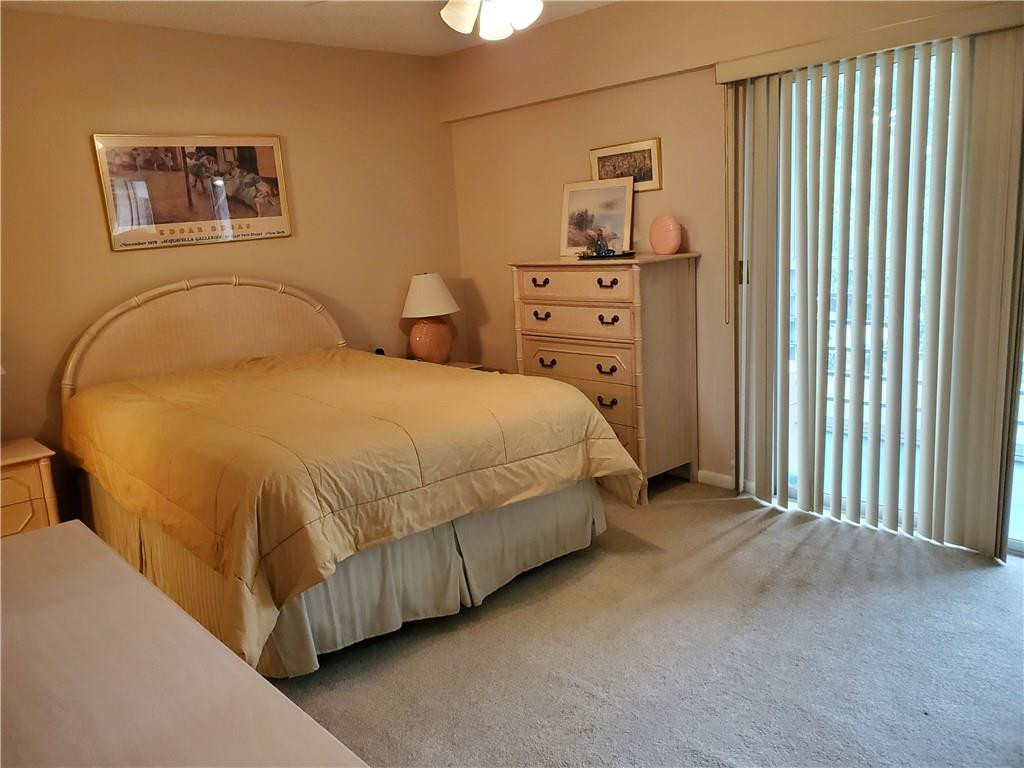 41 Suffolk A, Unit 41 Boca Raton, FL 33434 - Photo 9 of 12 a bedroom with a bed and dresser with mirror