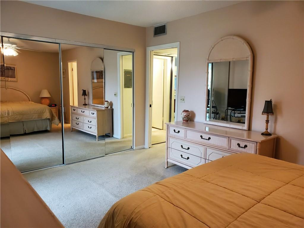 41 Suffolk A, Unit 41 Boca Raton, FL 33434 - Photo 10 of 12 a bedroom with a bed and a large mirror