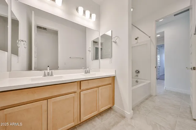 a bathroom with a double vanity sink mirror double and bathtub