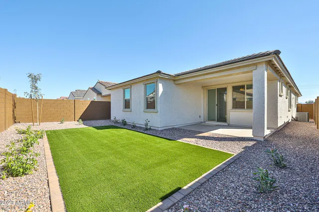 a view of a backyard with table and chairs and wooden fence