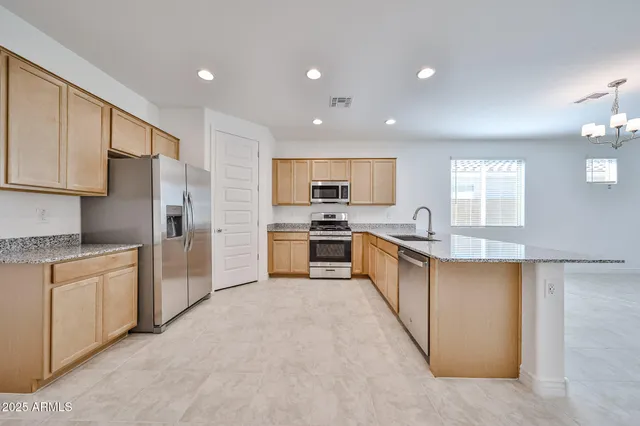 a large kitchen with stainless steel appliances lots of white cabinets