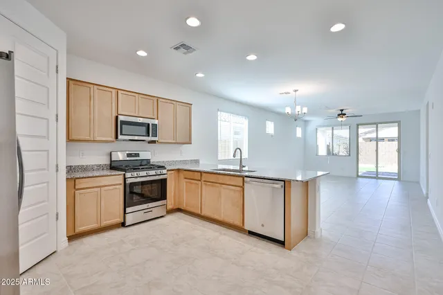 a large kitchen with granite countertop a stove top oven a sink a counter space and cabinets