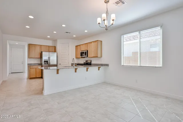 a view of kitchen with stainless steel appliances granite countertop lots of counter top space cabinets and a window