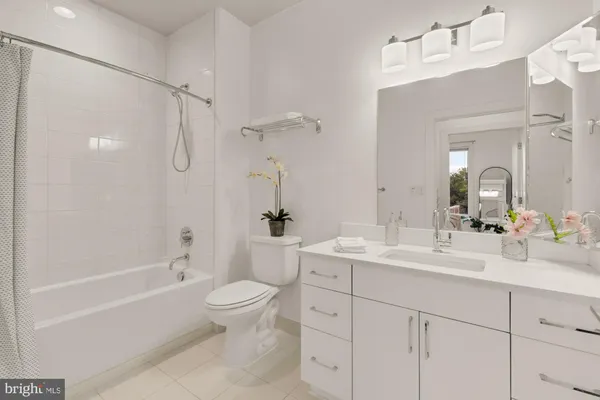 a bathroom with a double vanity sink toilet mirror and shower