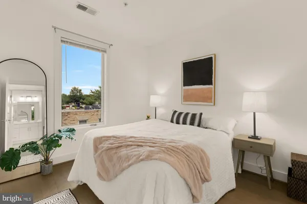 a bedroom with a bed and a potted plant