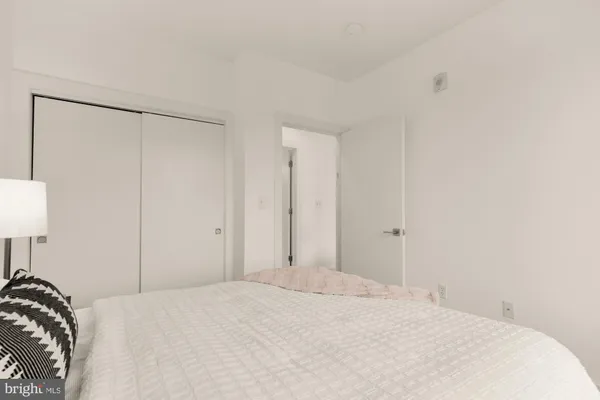 a view of a bedroom with a bed and a lamp