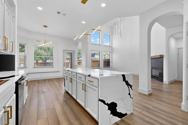 a kitchen with a sink and wooden floor