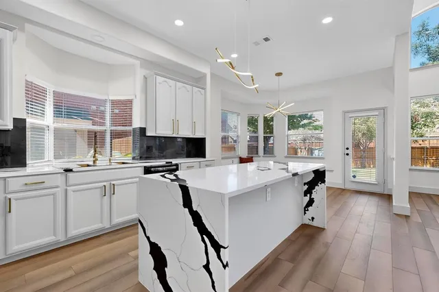 a kitchen with appliances a sink and cabinets