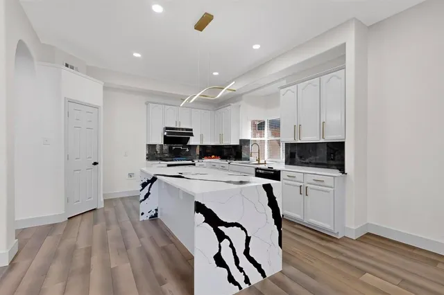 a kitchen with a sink a stove a refrigerator and cabinets