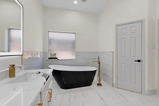 a bathroom with a sink a mirror and a bathtub