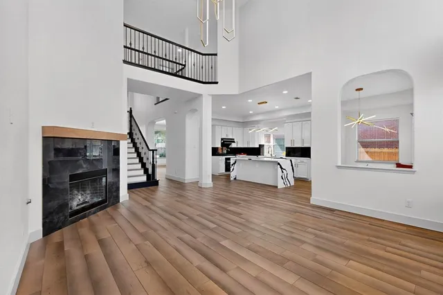 a view of a livingroom with wooden floor a ceiling fan and staircase