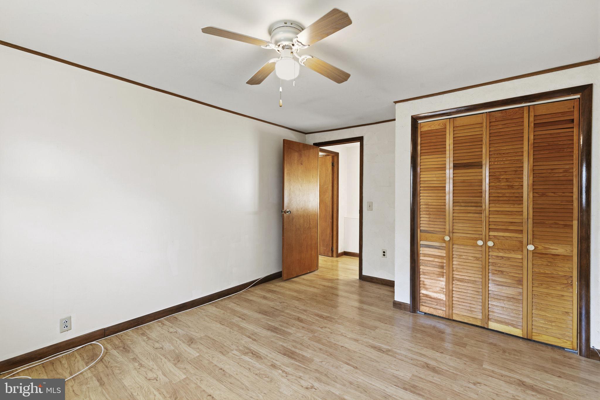 2411 Poplar Road Baltimore, MD 21221 - Photo 14 of 36 an empty room with wooden floor and door