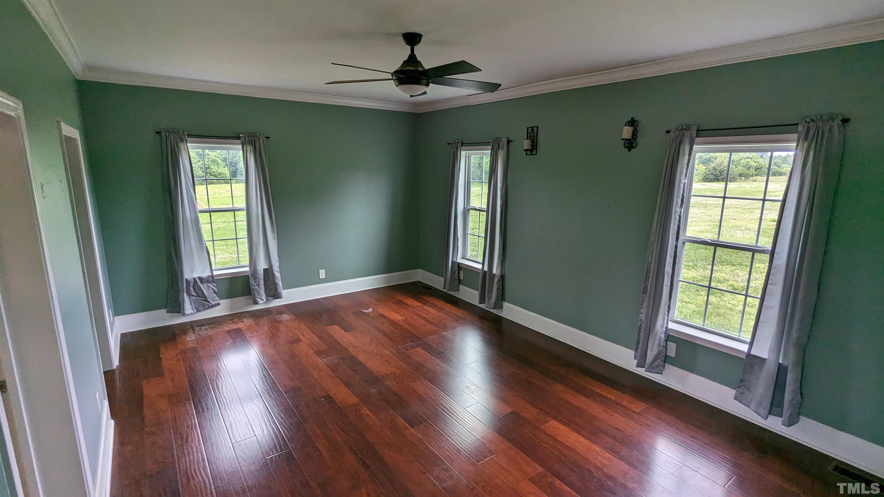 304 Bernard Purvis Road Bennett, NC 27208 - Photo 5 of 33 a view of an empty room with wooden floor and a window