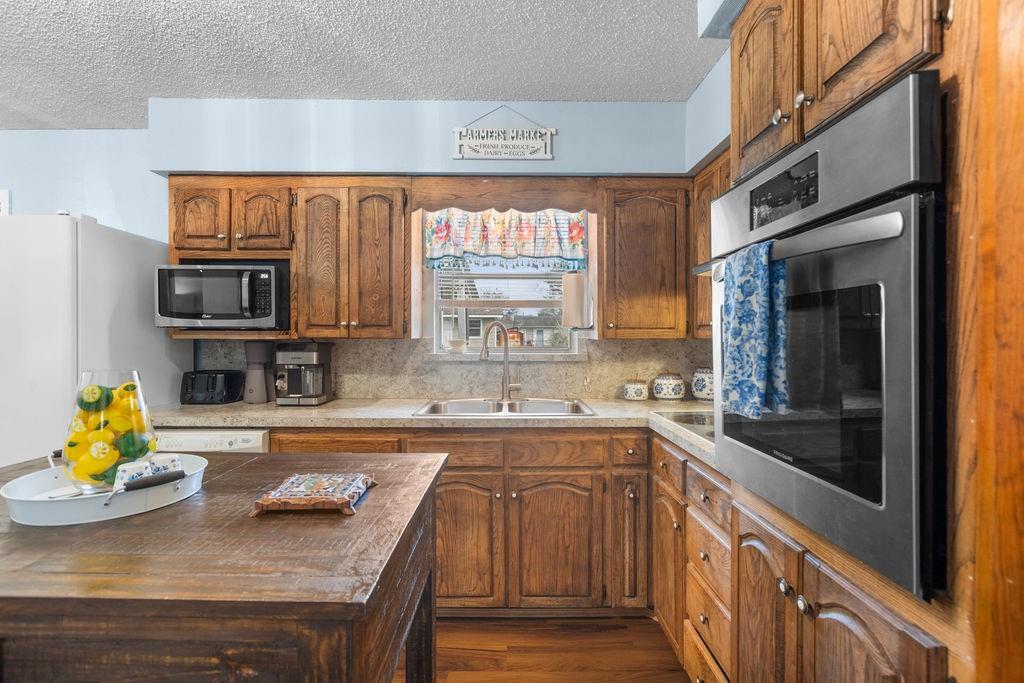 1320 Elm Street Bonham, TX 75418 - Photo 11 of 40 a kitchen with stainless steel appliances granite countertop a sink and cabinets