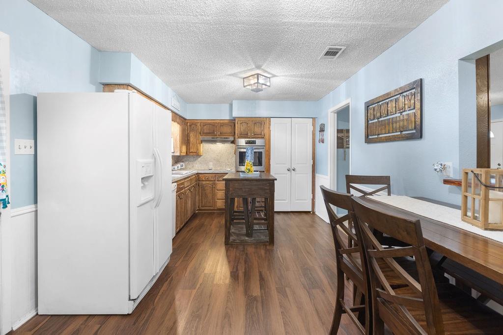 1320 Elm Street Bonham, TX 75418 - Photo 14 of 40 a kitchen with a table chairs refrigerator and microwave
